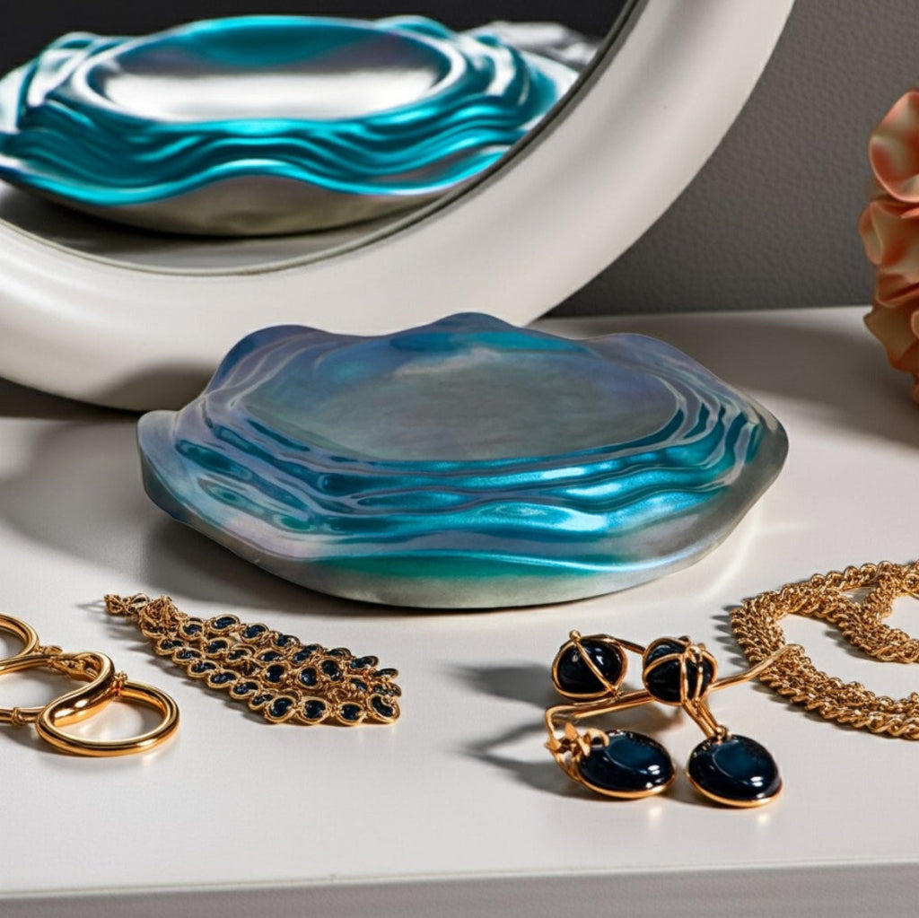 Decorative Trays - A decorative  jewellery decorative tray with a blue and teal wavy marbled pattern sits on a white tabletop, styled with gold jewellery and reflected in a white-framed mirror.