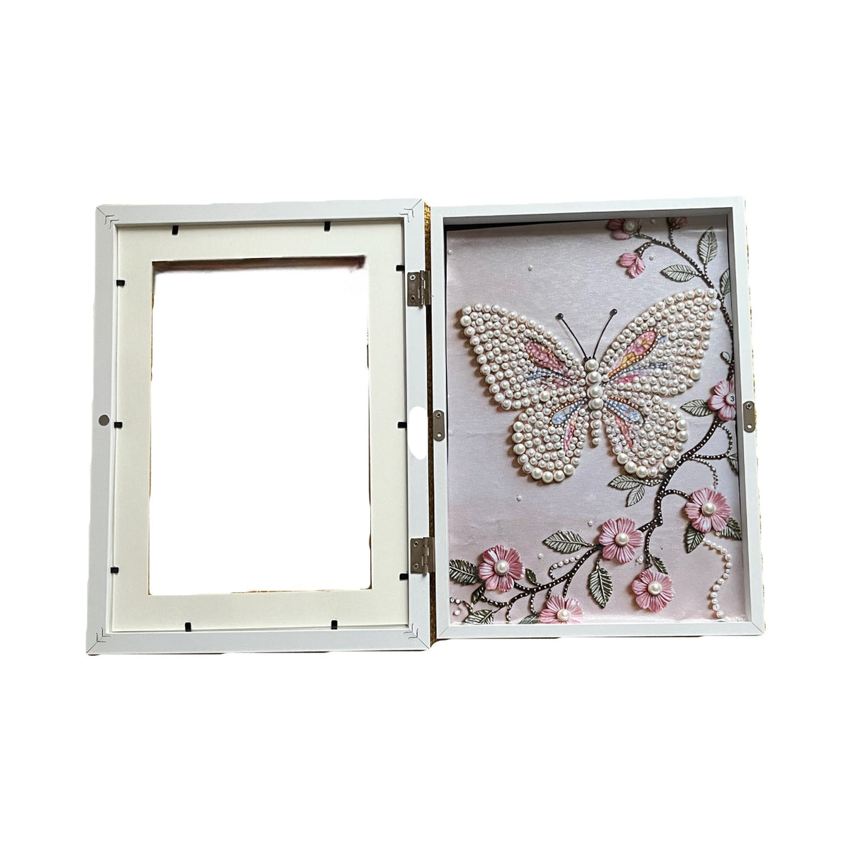 Decorative shadow box with a pearl butterfly and floral design on a white background
