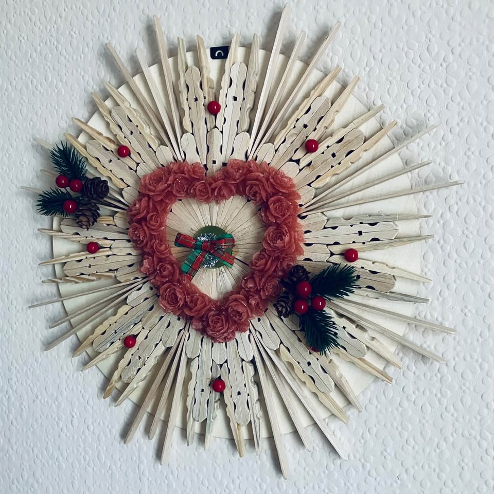 Wooden Christmas Wreath Handmade wall art featuring a heart-shaped design with natural pegs and holly berries.