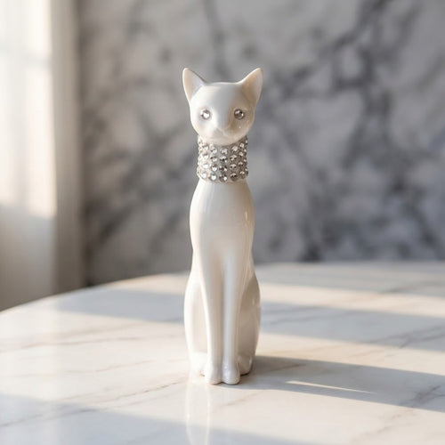 3D Printed Cat Figurine - A white cat figurine sitting upright on a light marble surface, wearing a rhinestone-studded collar, with a softly blurred grey marble background.