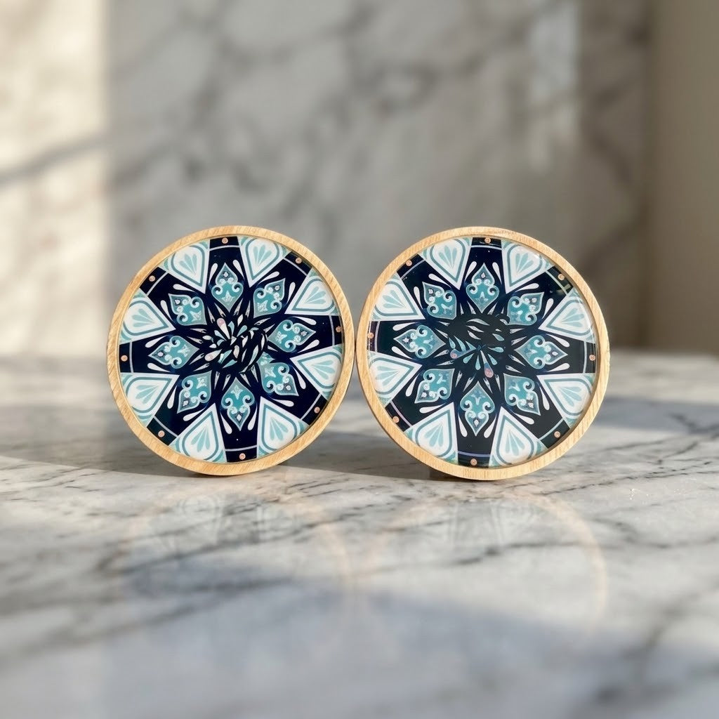 Mandala Bamboo Coasters - Two round coasters with a light wood rim and a black, white, and blue mandala pattern, displayed on a grey marble surface and background
