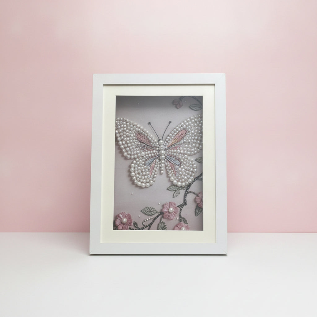 Framed artwork of a butterfly with pearls on a pink background