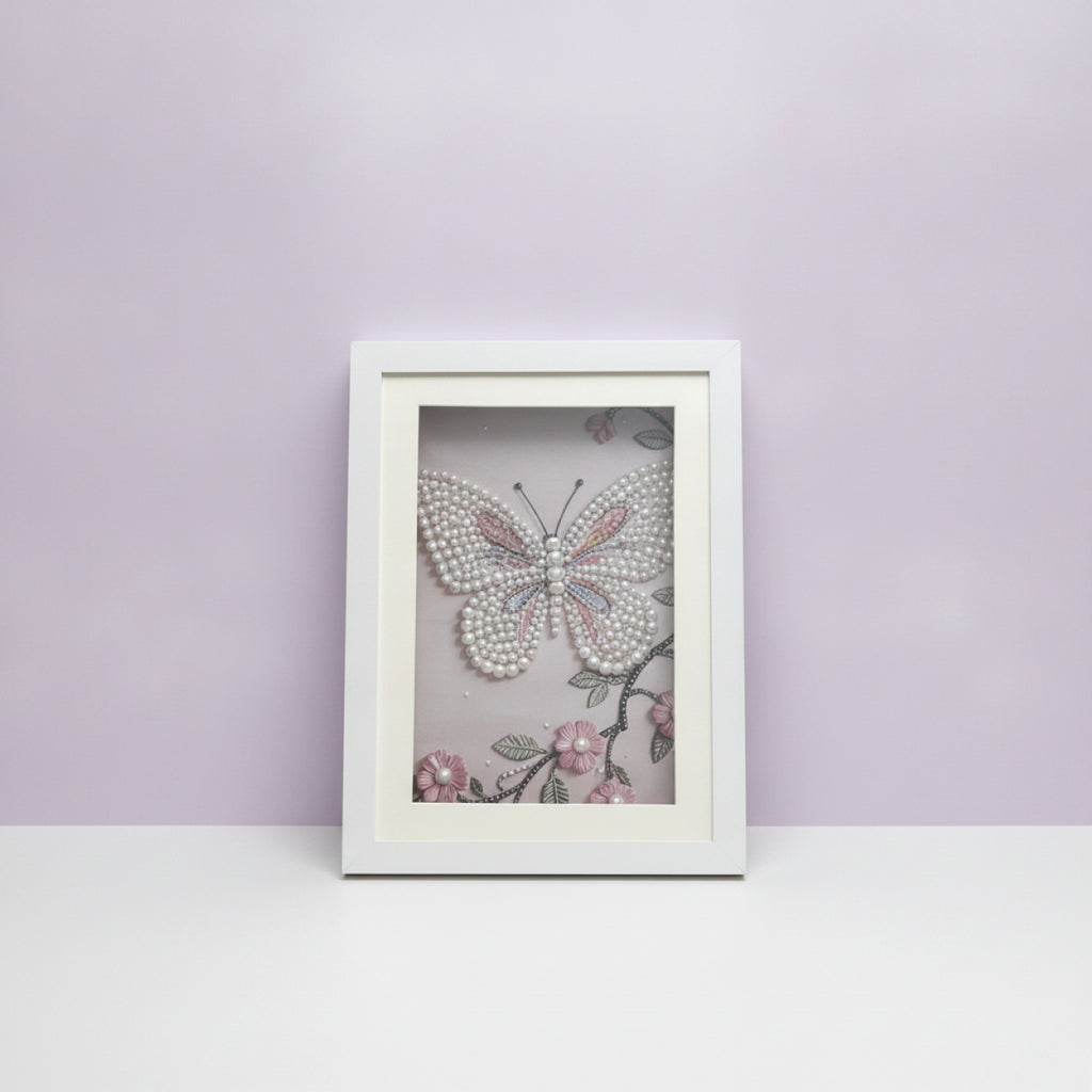 Framed artwork with a butterfly design embossed with pearl gems on a light purple background
